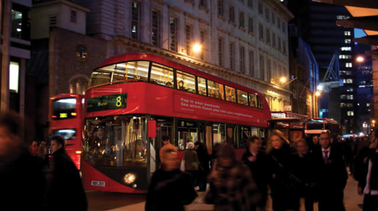 The picture depicts a double decker bus in a crowd of people.